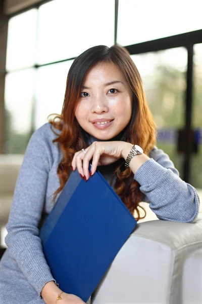 Lachende Aziatische zakenvrouw houden met map in office — Stockfoto