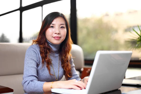 Lachende Aziatische zakelijke vrouw met laptop — Stockfoto