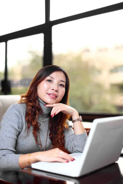 Lachende Aziatische zakelijke vrouw met laptop — Stockfoto