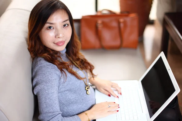 Leende asiatisk affärskvinna med laptop — Stockfoto