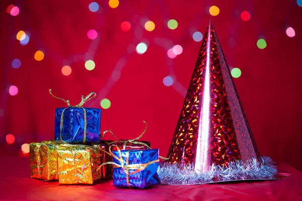 Presente de Natal e boné com fundo vermelho — Fotografia de Stock