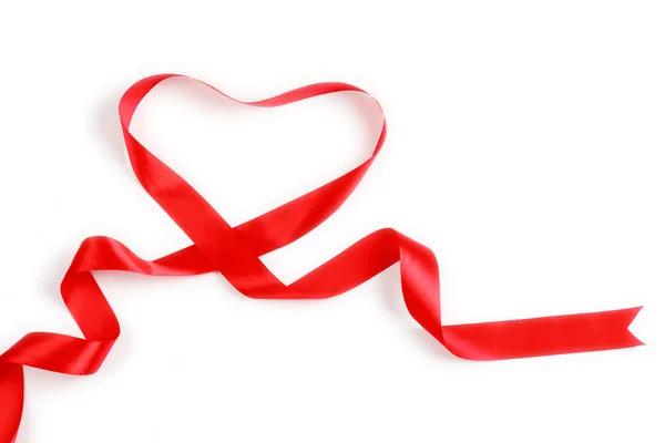 Shiny red satin ribbon with heart shape on white background with copy space. Macro with extremely shallow dof. Stock Picture