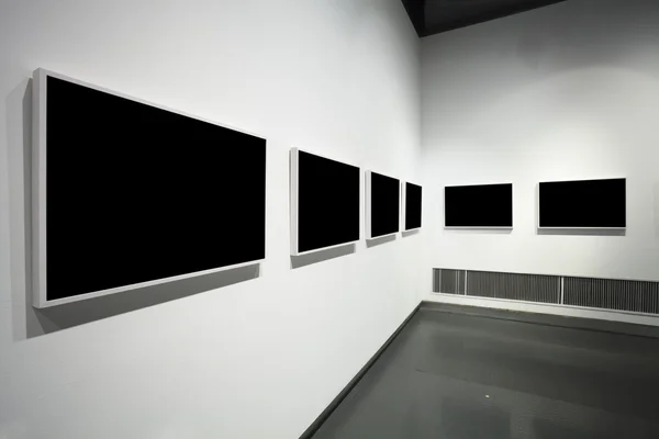 Frames on white wall in art museum — Stock Photo, Image