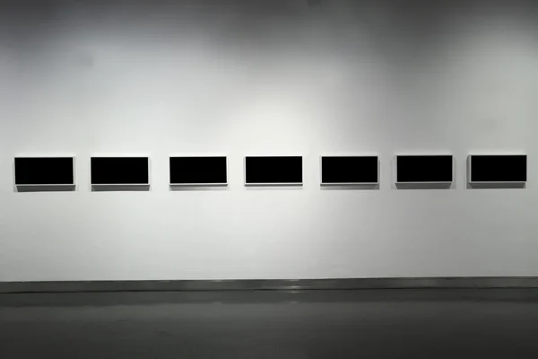 Frames on white wall in art museum — Stock Photo, Image