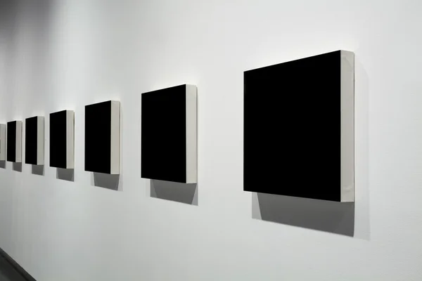 Frames on white wall in art museum — Stock Photo, Image