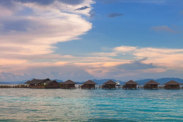 Bungalow sobre agua con cielo bullicioso — Foto de Stock