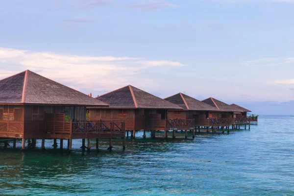 Bungalow sobre agua con cielo bullicioso — Foto de Stock