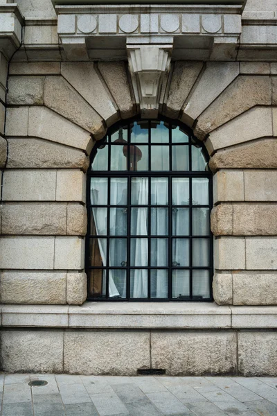 Oude gebouw buitenkant met gewelfde venster — Stockfoto