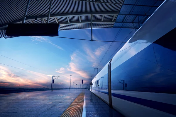 Зупинка поїзда на залізничному вокзалі з заходом сонця — стокове фото