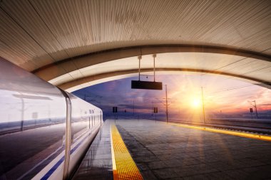 Tren istasyonunda gün batımında tren durağı