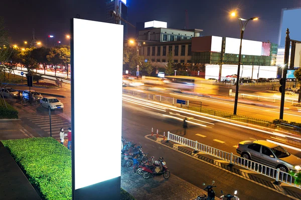 Publicidade de exibição branca com tráfego à noite — Fotografia de Stock