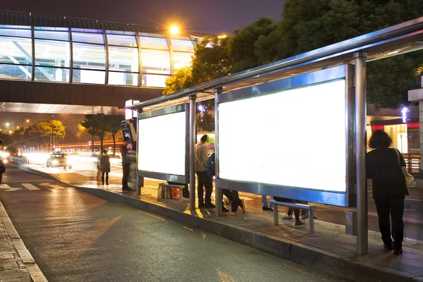 Estação de ônibus noturna com outdoor em branco — Fotografia de Stock