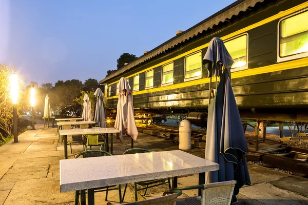 Outdoor cafe bar with an old train background — Stock Photo, Image