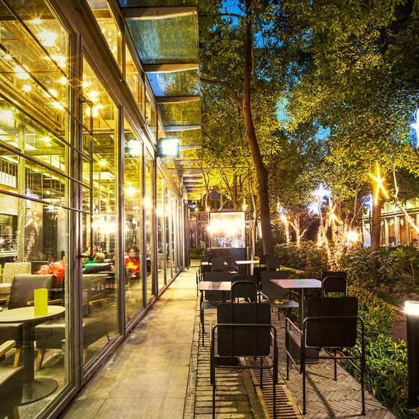 Illuminated restaurant with long footpath — Stock Photo, Image