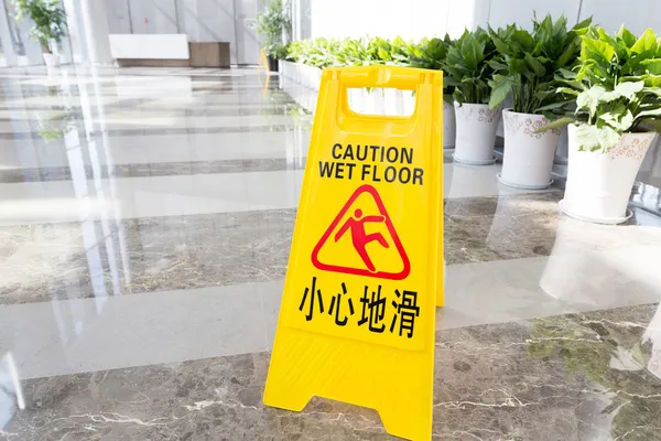 Schild warnt vor nassem Boden — Stockfoto