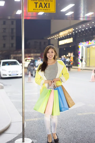 Счастливая женщина делает покупки и держит сумки девочки — стоковое фото