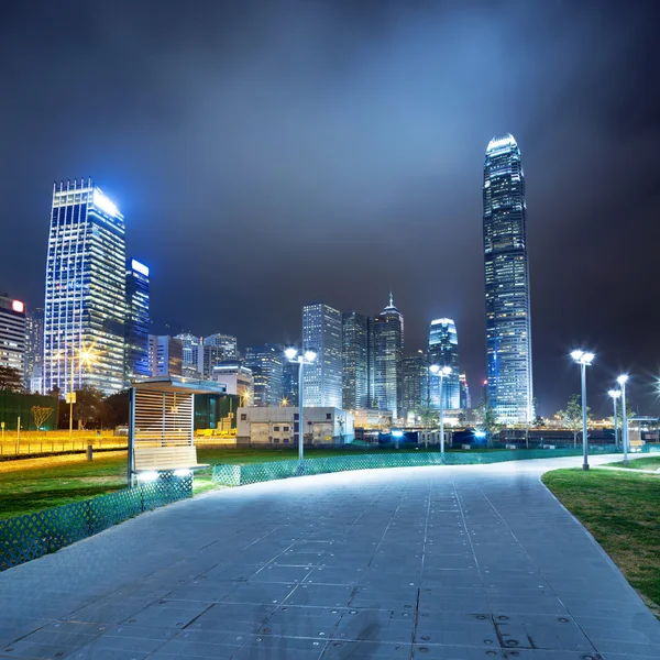 Pathway in the night with modern city background — Stock Photo, Image