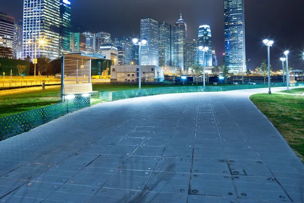 Pathway in the night with modern city background — Stock Photo, Image