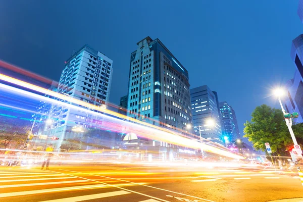 Car light trails and urban landscape in modern city — Stock Photo, Image