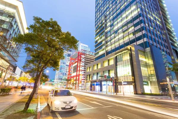 Auto licht paden en stedelijk landschap in moderne stad — Stockfoto