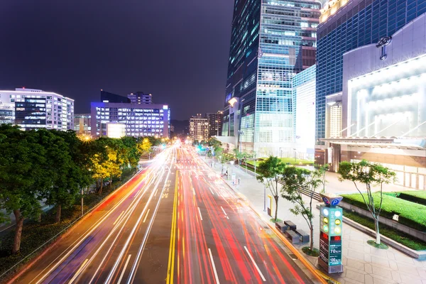 Auto licht paden en stedelijk landschap in moderne stad — Stockfoto