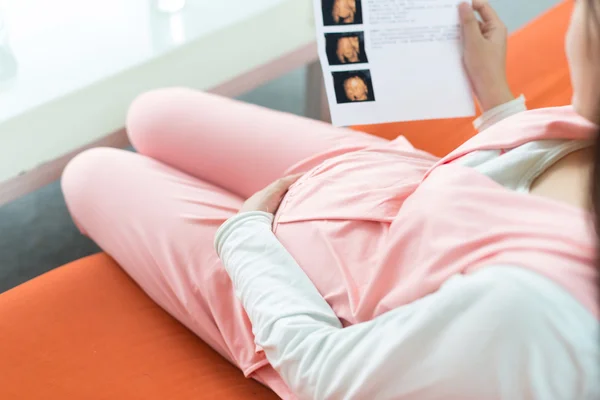 Foto van zwangere vrouw liggen en verslag te kijken — Stockfoto