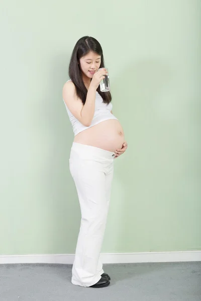 Красивая беременная женщина пьет — стоковое фото