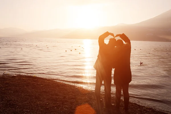 Due persone posano per amore accanto al lago — Foto Stock