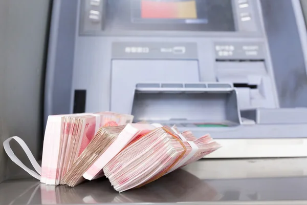 Terugtrekking een heleboel cny van de ATM- — Stockfoto