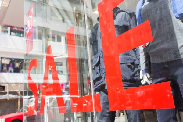 Sinal de venda na janela da loja de roupas — Fotografia de Stock