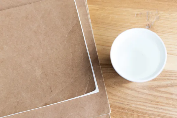 Arbeitsplatz mit Tasse, Notizbuch auf Holztisch — Stockfoto