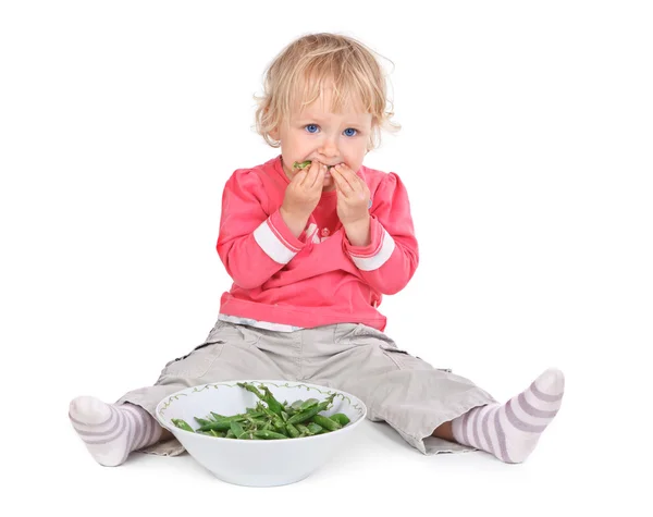 Menina pequena comendo ervilhas grean — Fotografia de Stock