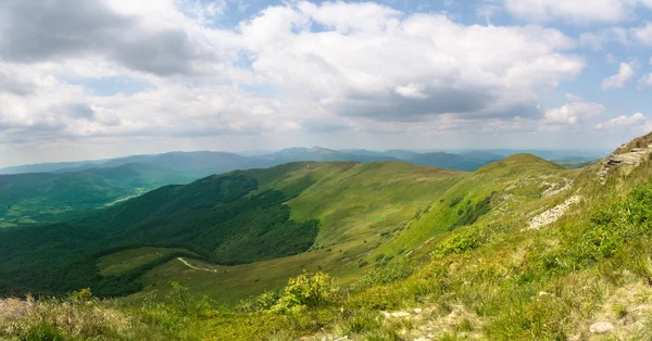Schönes grünes Bergpanorama mit blauem Himmel darüber — Stockfoto