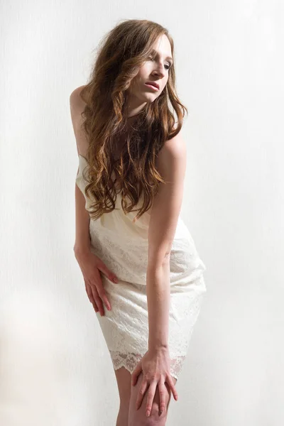 Parlak Arkaplan Önünde Kısa Beyaz Bir Elbise Giyen Güzel Bir — Stok fotoğraf