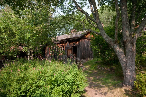 Oud houten huis in een tuin — Stockfoto