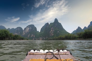 Bamboo raft and karst mountain landscape clipart