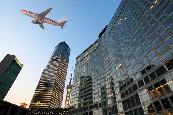 Airplane on the modern city — Stock Photo, Image