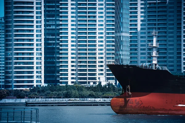 Abstracte stadsgezicht van vrachtschip met moderne gebouwen — Stockfoto