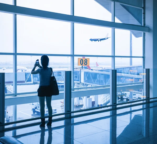 Menina na janela do aeroporto e chegada do voo — Fotografia de Stock