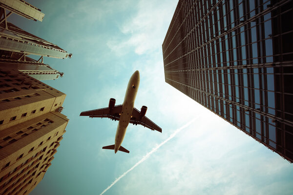 Airplane and modern buildings with dramatic sky,abstract cityscape