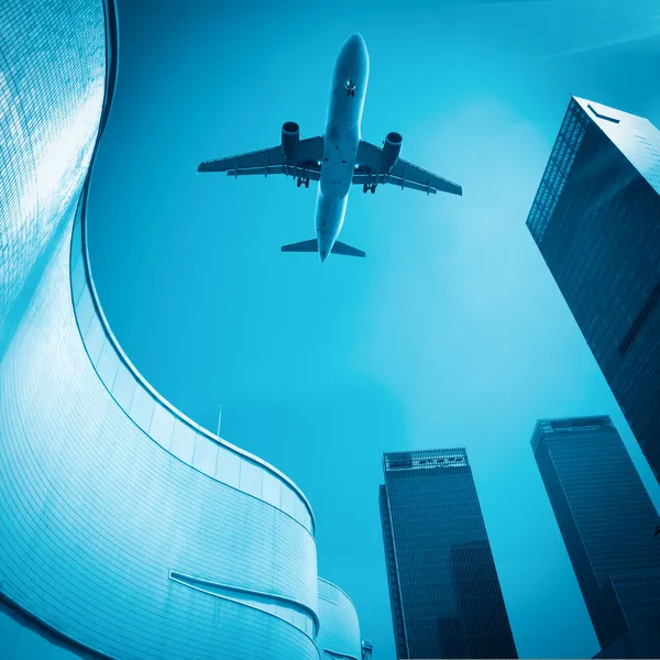 Airplane and modern buildings — Stock Photo, Image