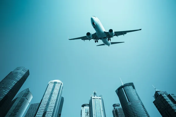 Flugzeug mit Skyline moderner Gebäude — Stockfoto