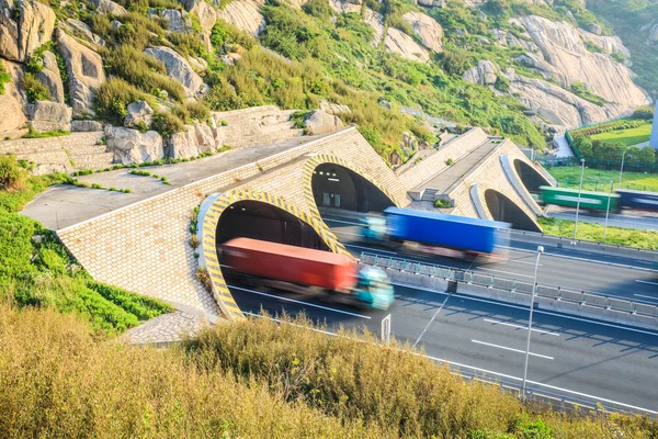 Caminhões movimento borrão na saída do túnel — Fotografia de Stock