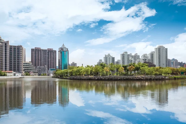 Schöne Stadt am Fluss vor blauem Himmel — Stockfoto