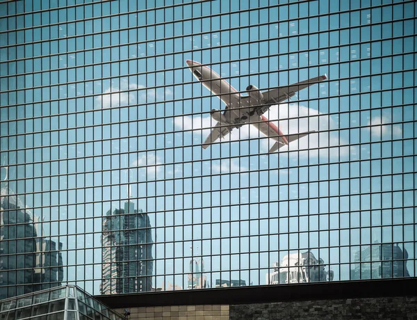 Airplane are reflected on the glass curtain wall — Stock Photo, Image