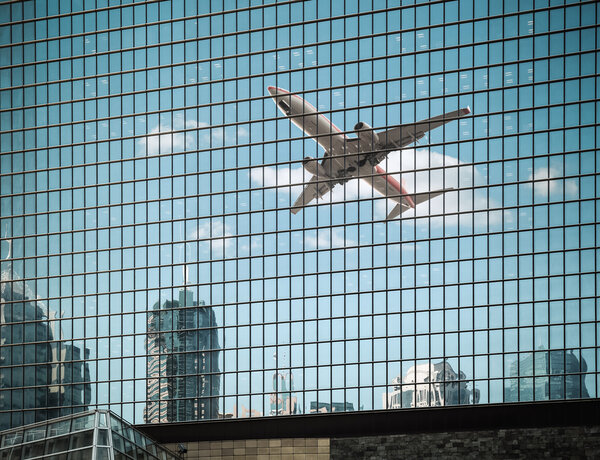 Modern glass curtain wall building with airplane reflection ,abstract cityscap