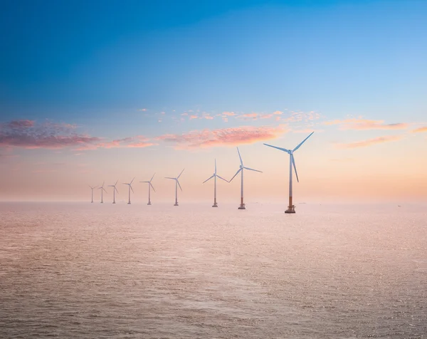 Elektrowni wiatrowych w morzu w zachód słońca — Zdjęcie stockowe