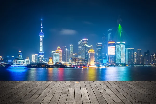 Shanghai skyline por la noche con piso de madera — Foto de Stock