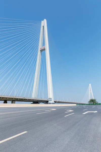 空旷的柏油路和斜拉桥在蓝天的映衬下 桥塔上的汉字读作 五雪桥 — 图库照片