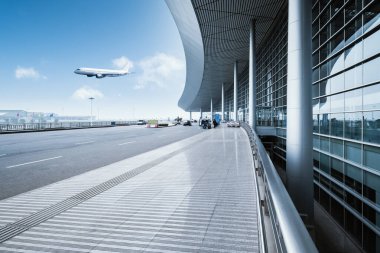 Mavi gökyüzü ve uçağa karşı modern havaalanı sahnesi